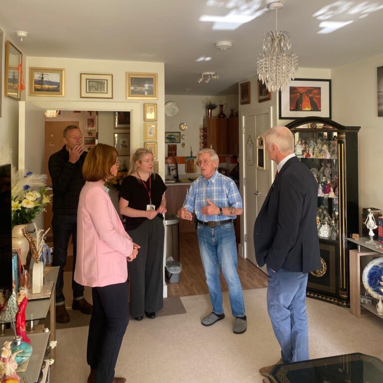 MP for Aldershot Alex Baker and Minister for Veterans and People Al Carns speaking to veteran Derek in his flat.